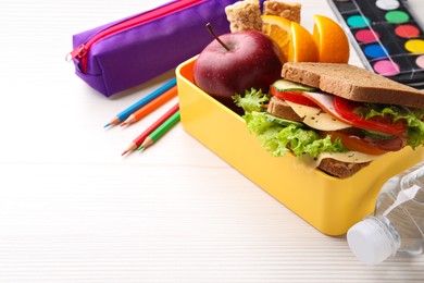 Photo of Lunch box with healthy food and different stationery on white wooden table, closeup. Space for text