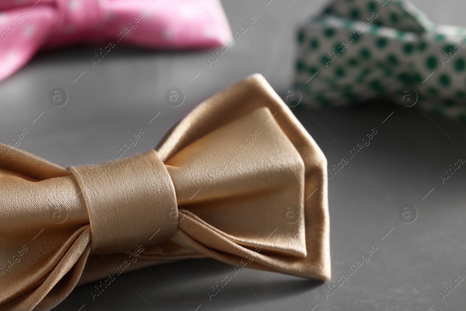 Photo of Stylish pale yellow bow tie on gray background, closeup