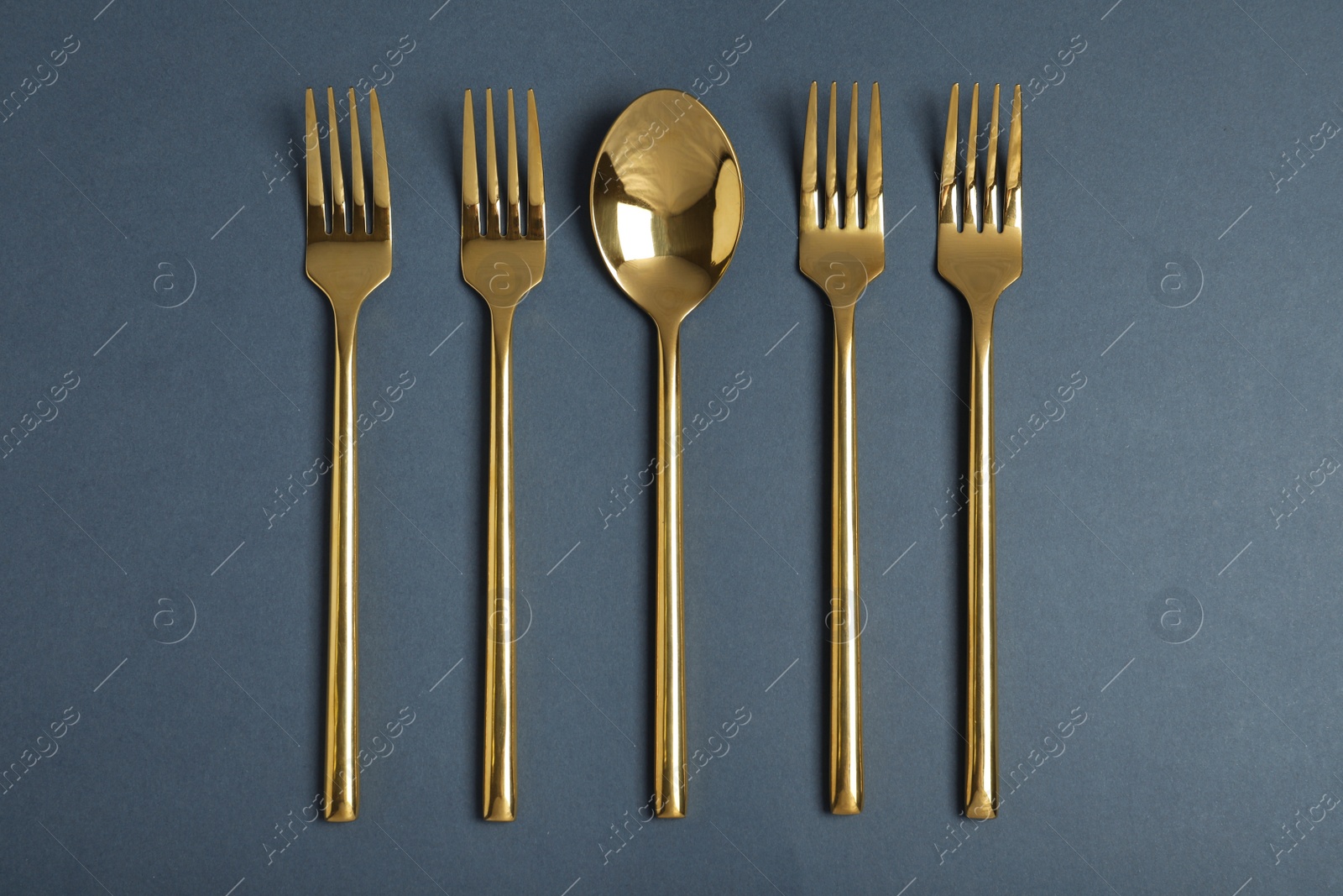 Photo of Flat lay composition with gold cutlery on grey background