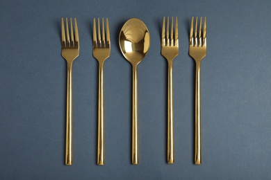 Photo of Flat lay composition with gold cutlery on grey background