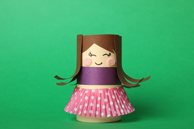 Photo of Toy doll made of toilet paper hub on green background