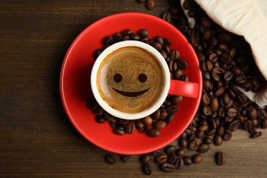 Image of Cup of tasty coffee and beans on wooden table, flat lay. Good morning