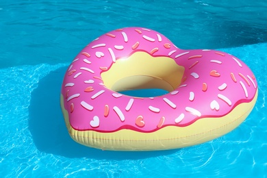 Photo of Heart shaped inflatable heart floating in swimming pool on sunny day