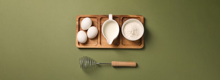 Metal whisk, eggs, milk and flour on khaki background, top view. Banner design