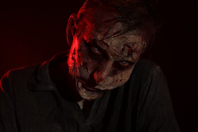 Photo of Scary zombie on dark background. Halloween monster