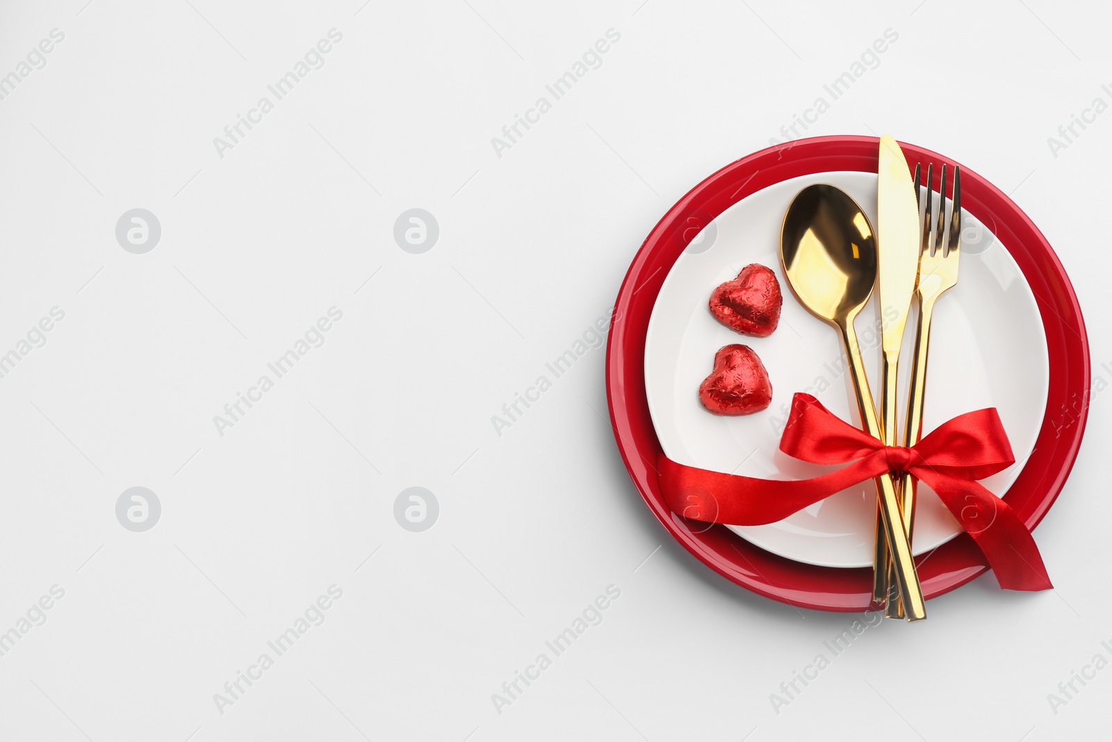 Photo of Beautiful table setting on white background, top view with space for text. Valentine's Day dinner