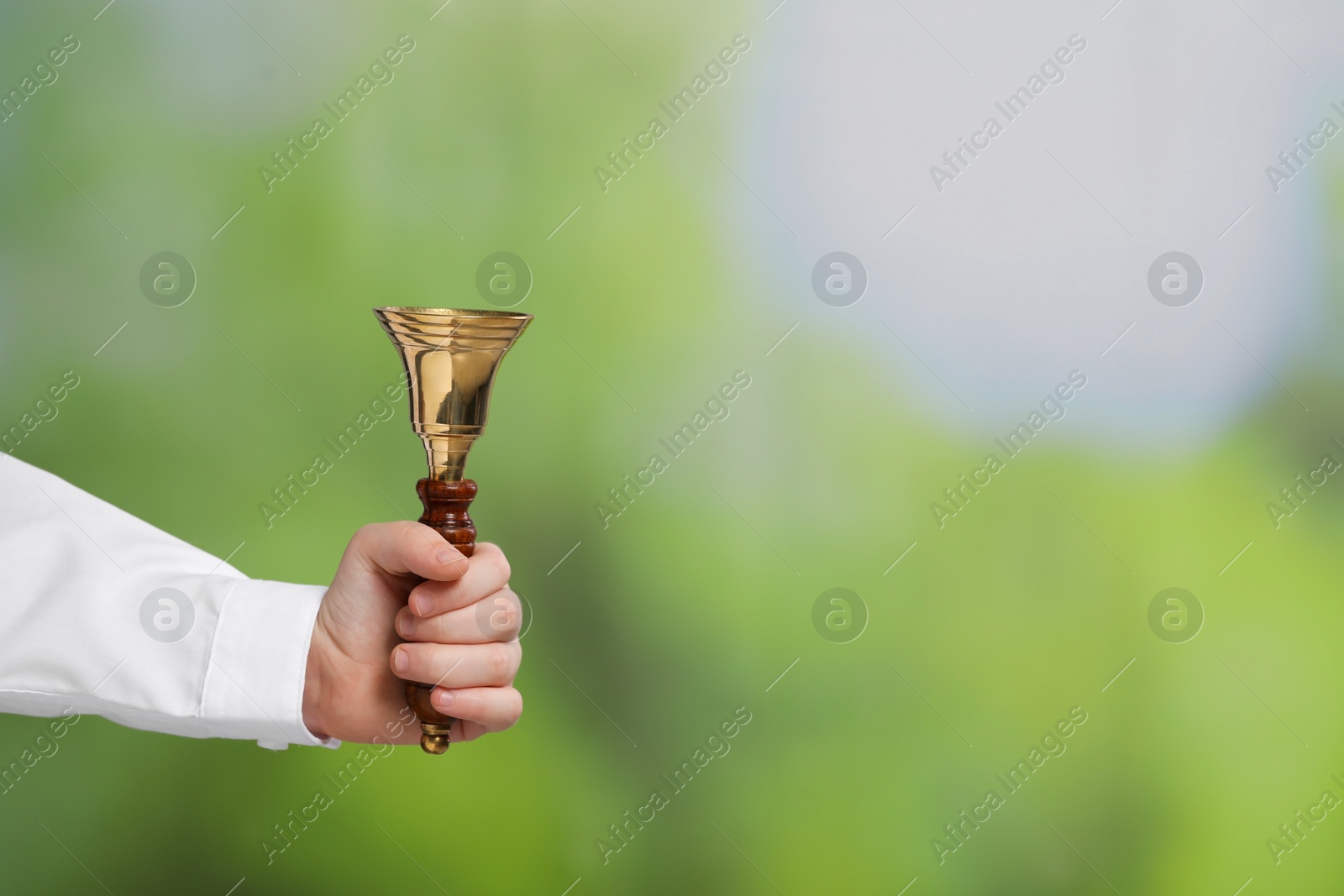 Photo of Pupil with school bell outdoors, closeup. Space for text