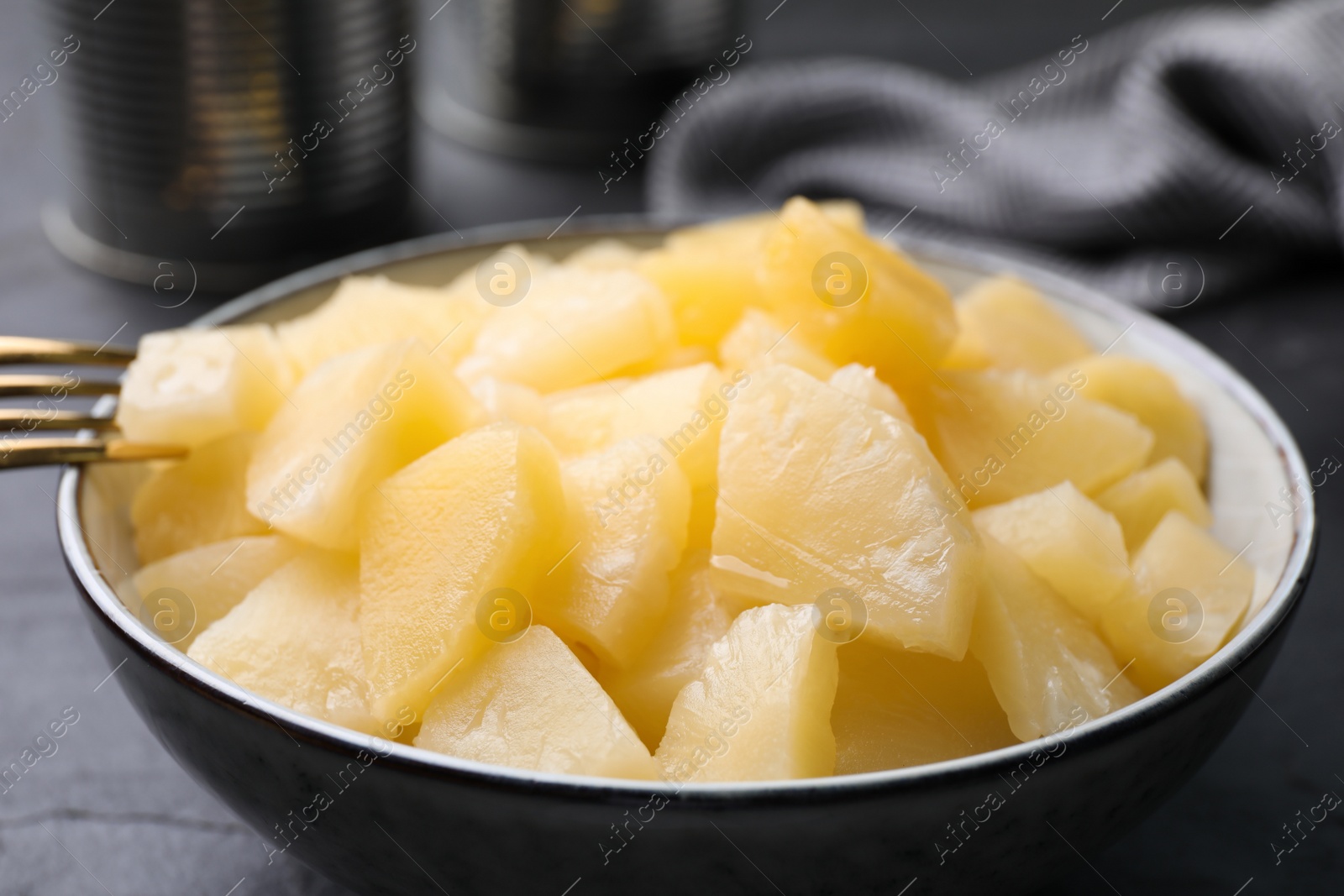 Photo of Pieces of delicious canned pineapple in bowl, closeup