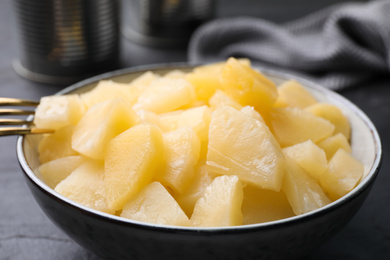 Photo of Pieces of delicious canned pineapple in bowl, closeup