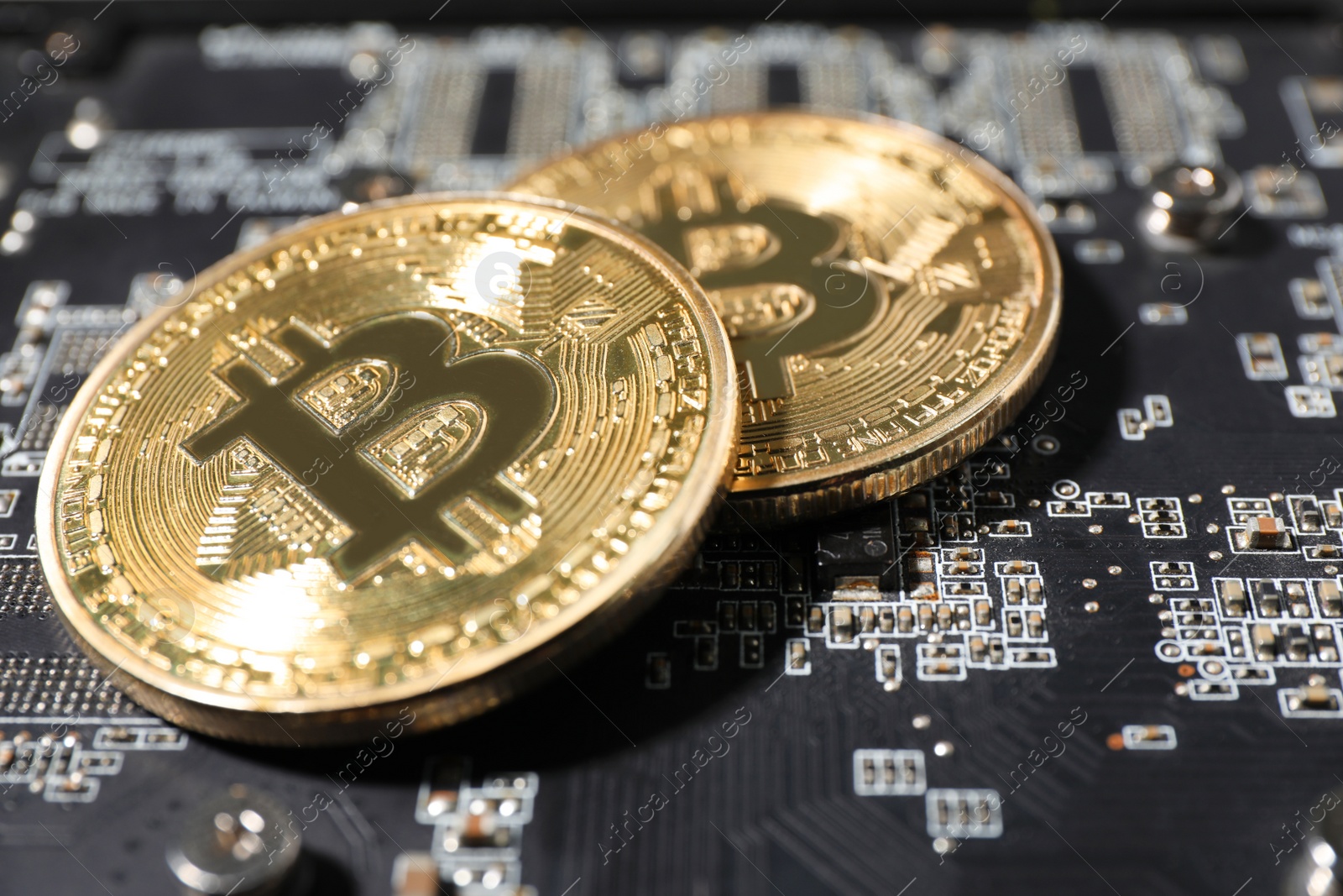 Photo of Golden bitcoins on computer circuit board, closeup. Space for text