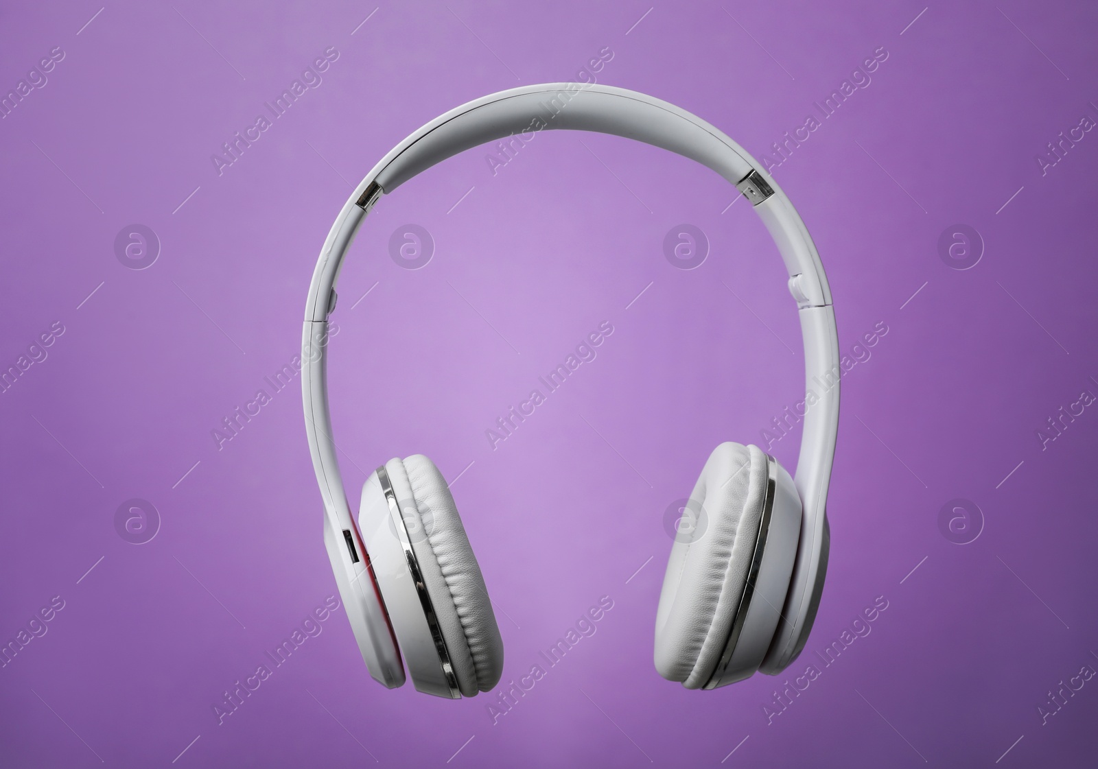 Photo of Wireless headphones with earmuffs on color background