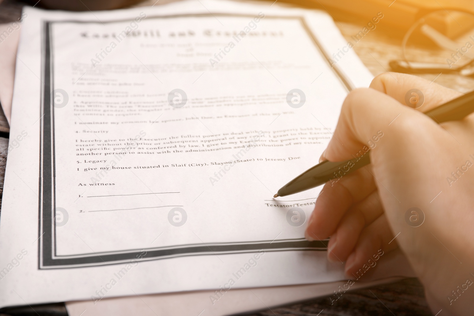 Image of Woman signing Last Will and Testament at table, closeup