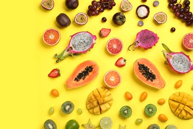Photo of Many different delicious exotic fruits on yellow background, flat lay
