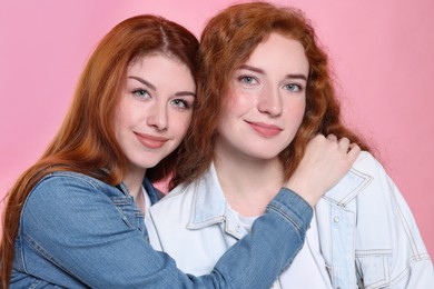 Photo of Portrait of beautiful young redhead sisters on pink background