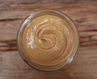 Tasty nut paste in jar on table, top view