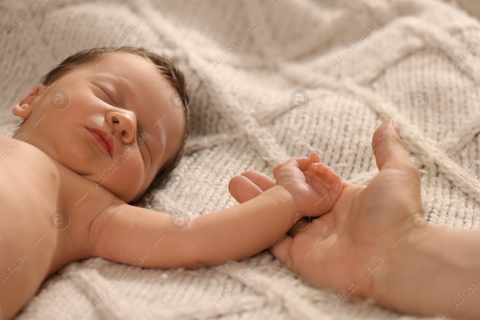 Photo of Mother with her newborn baby on beige blanket, closeup. Lovely family