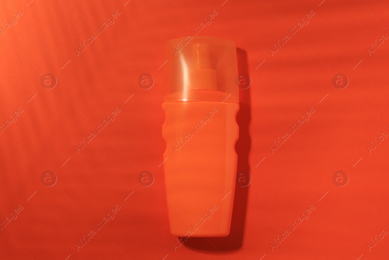 Photo of Sunscreen on coral background, top view. Sun protection care