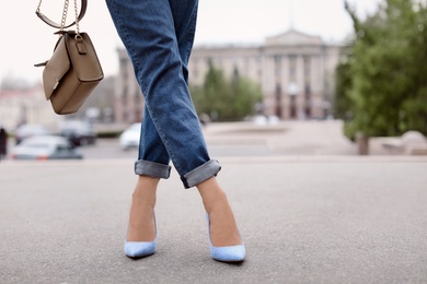 Photo of Young woman in elegant shoes walking on street