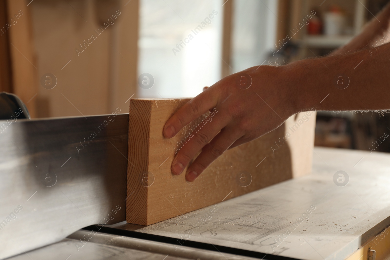 Photo of Professional carpenter working with wood in shop, closeup