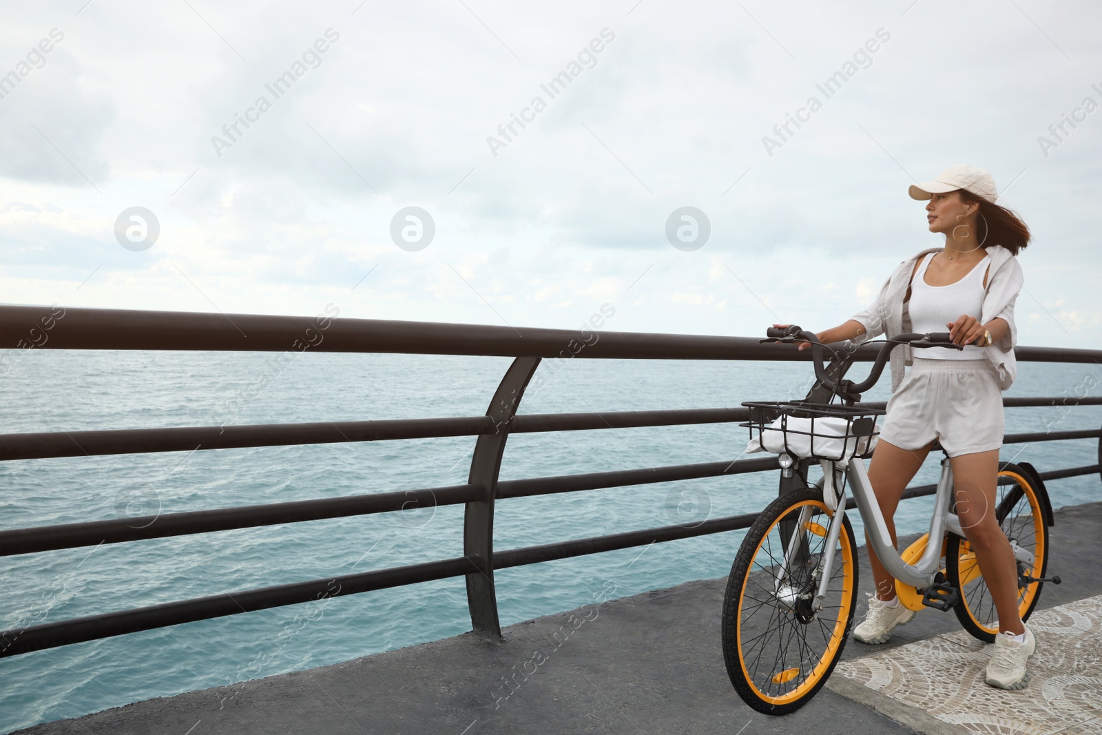 Photo of Beautiful young woman with bicycle near sea. Space for text