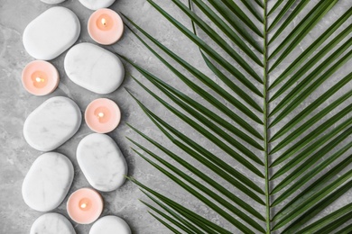 Flat lay composition with spa stones and candles on grey marble background