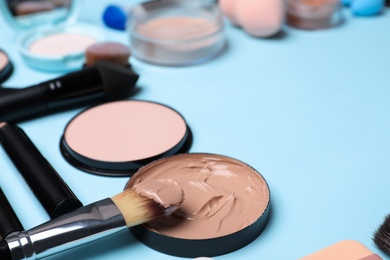 Photo of Composition with skin foundation, powder and beauty accessories on color background. Space for text