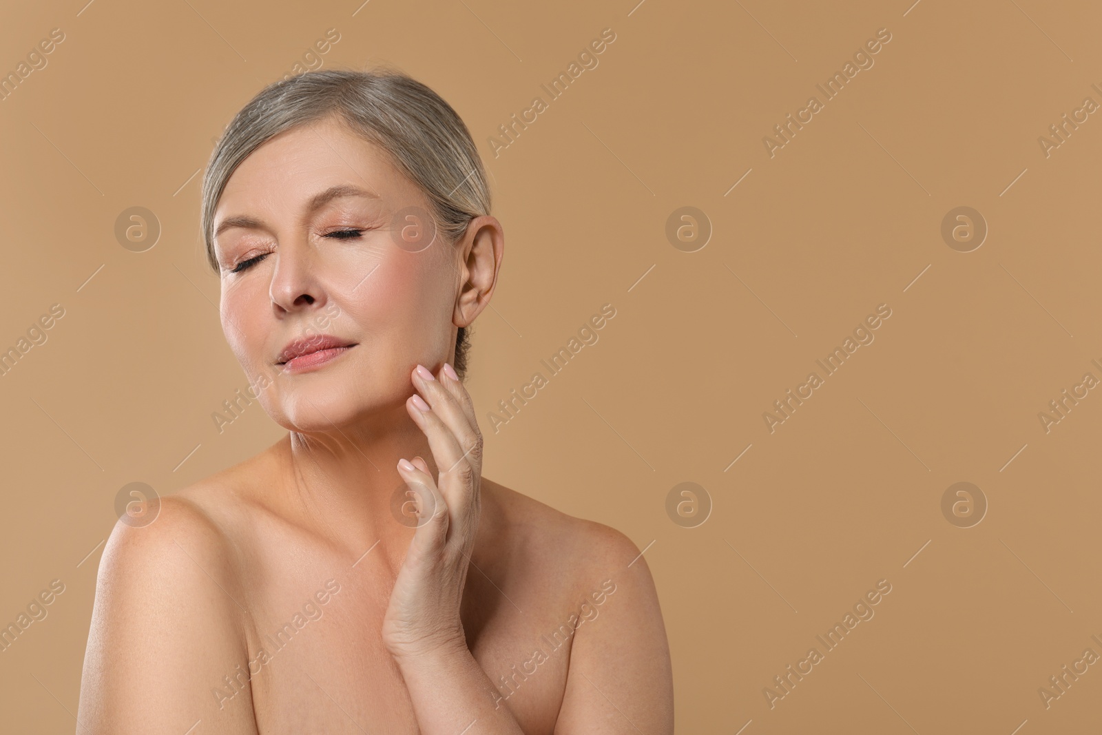 Photo of Beautiful mature woman with healthy skin on beige background, space for text