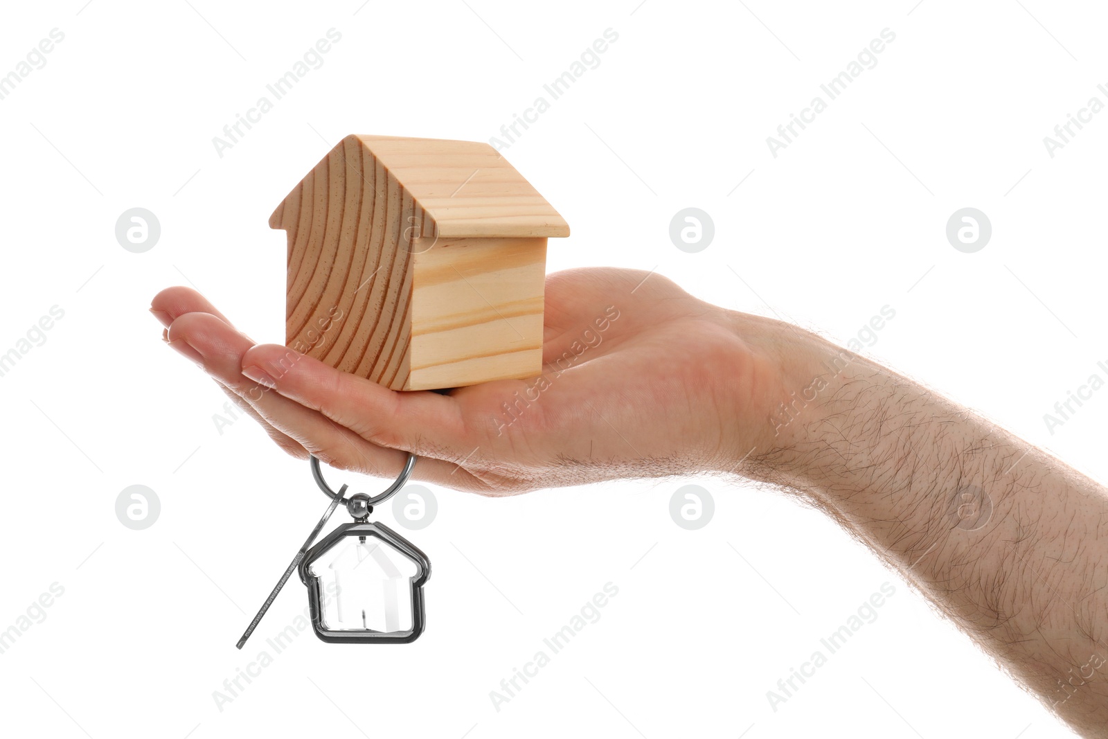 Photo of Real estate agent holding house figure and key on white background, closeup