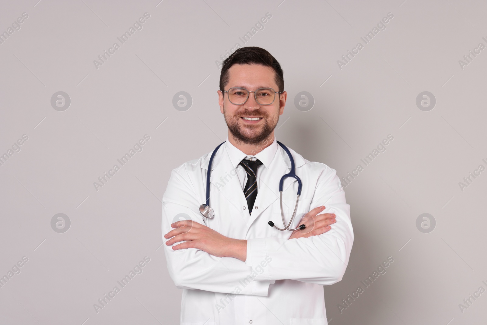 Photo of Portrait of smiling doctor on light grey background