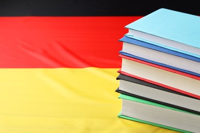 Photo of Learning foreign language. Different books on flag of Germany, space for text