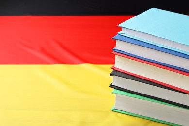 Learning foreign language. Different books on flag of Germany, space for text