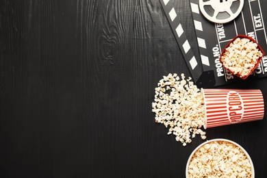 Flat lay composition with tasty popcorn and space for text on wooden background. Cinema snack