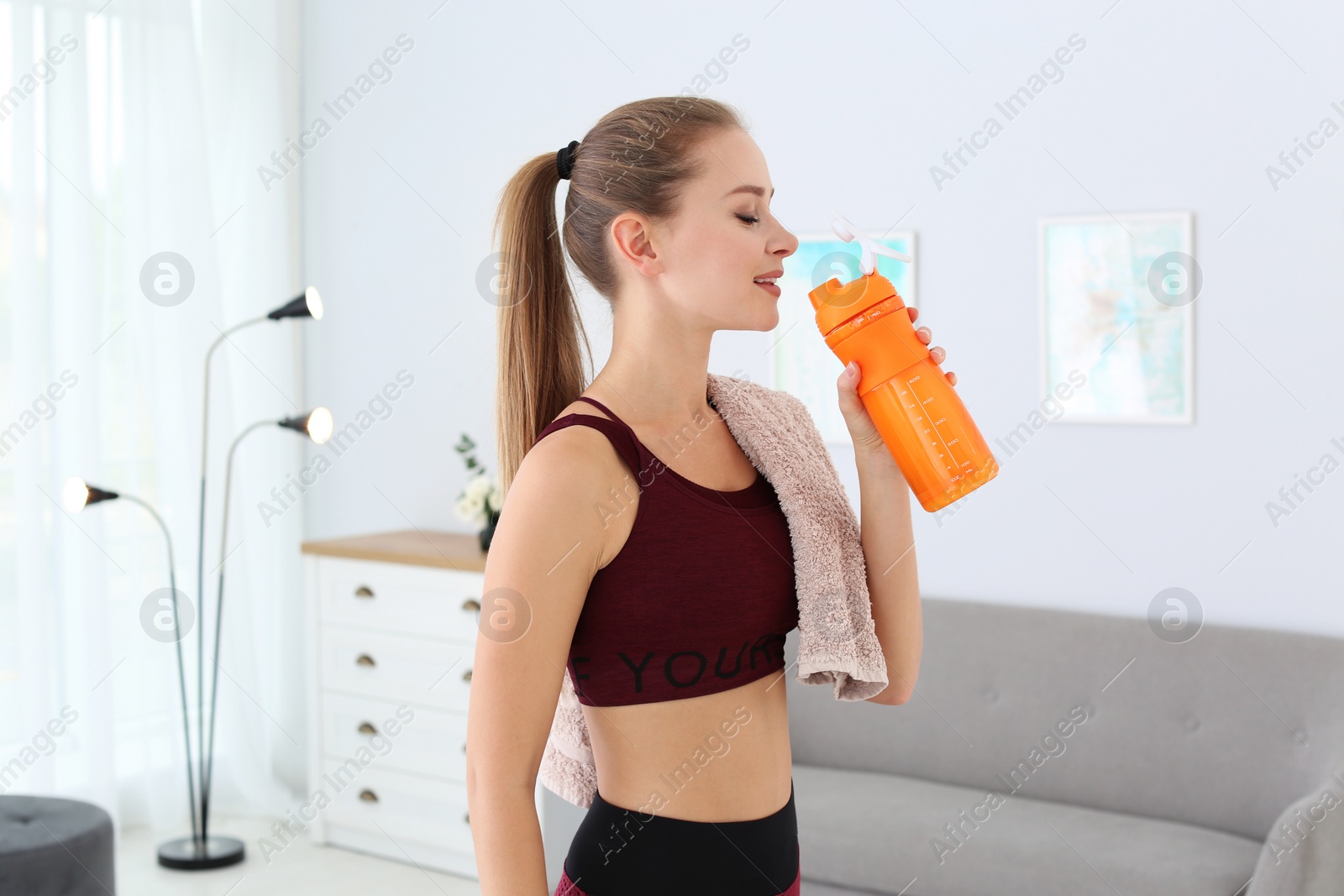 Photo of Woman drinking protein shake in living room