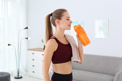 Woman drinking protein shake in living room