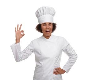 Photo of Happy female chef in uniform showing ok gesture on white background