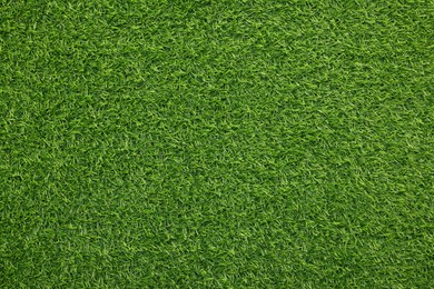 Green artificial grass as background, top view