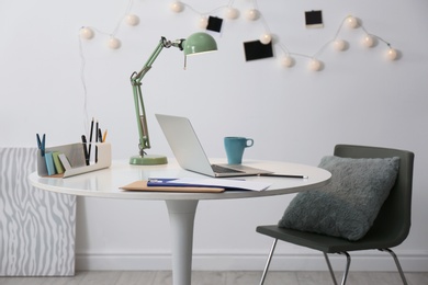 Stylish workplace with laptop on table in office