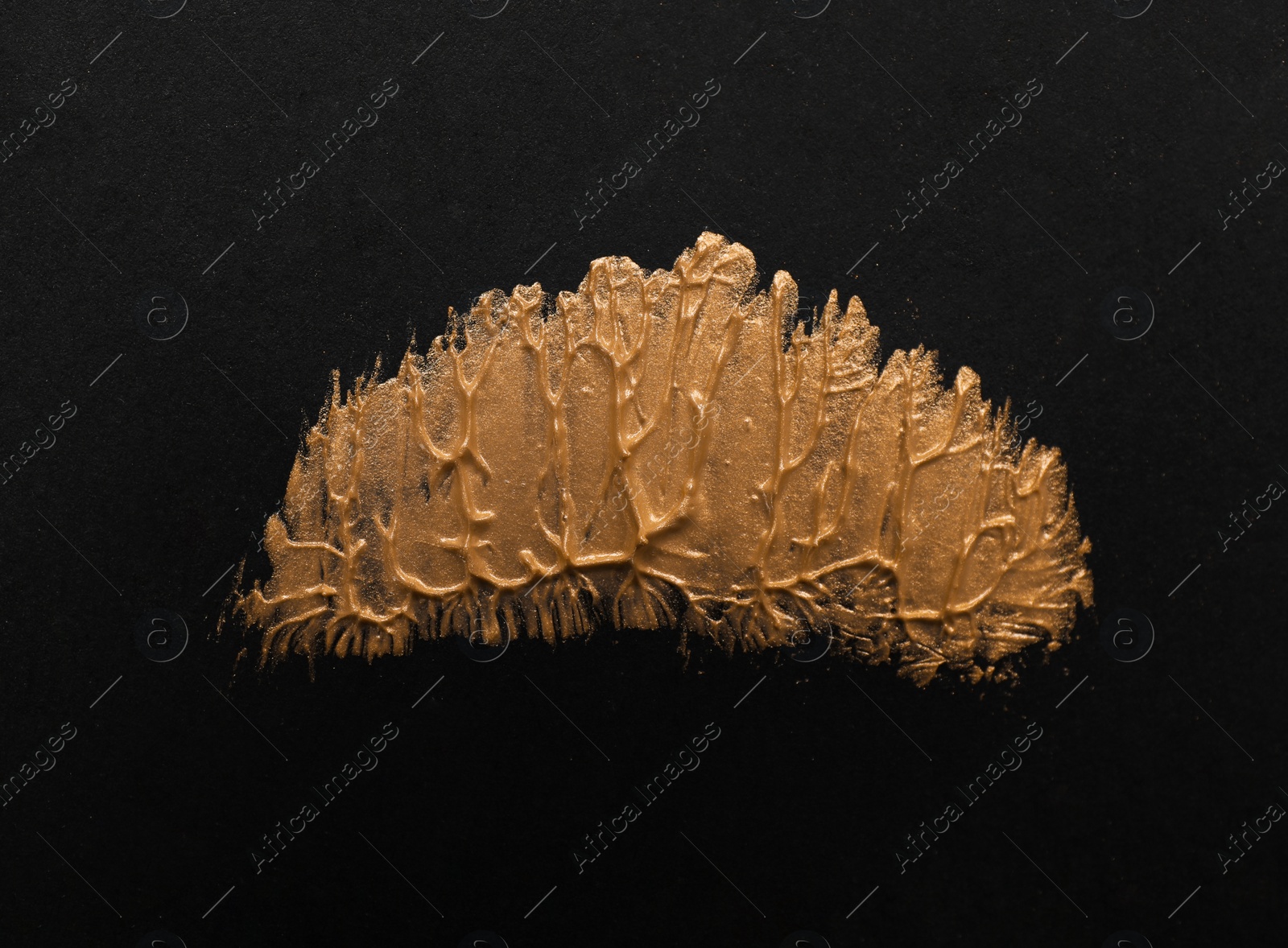 Photo of Golden paint on black background. Stylish design