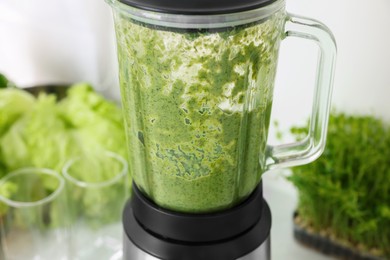 Photo of Blender with delicious smoothie indoors, closeup view