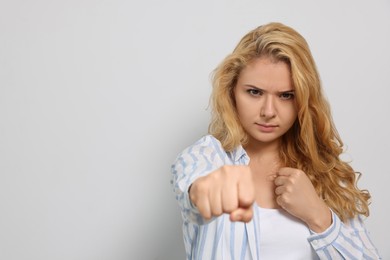 Photo of Young woman ready to fight on white background. Space for text