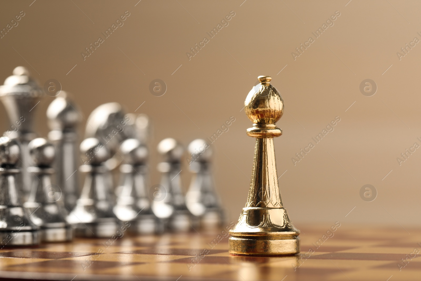 Photo of Chessboard with game pieces on beige background, closeup. Space for text