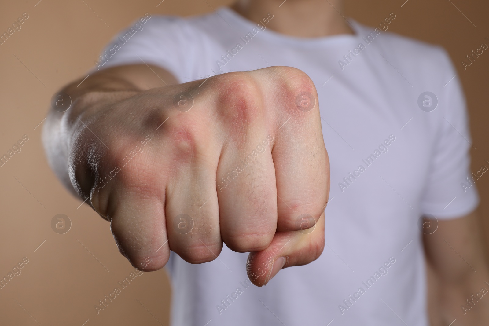 Photo of Man showing fist with space for tattoo on beige background, selective focus