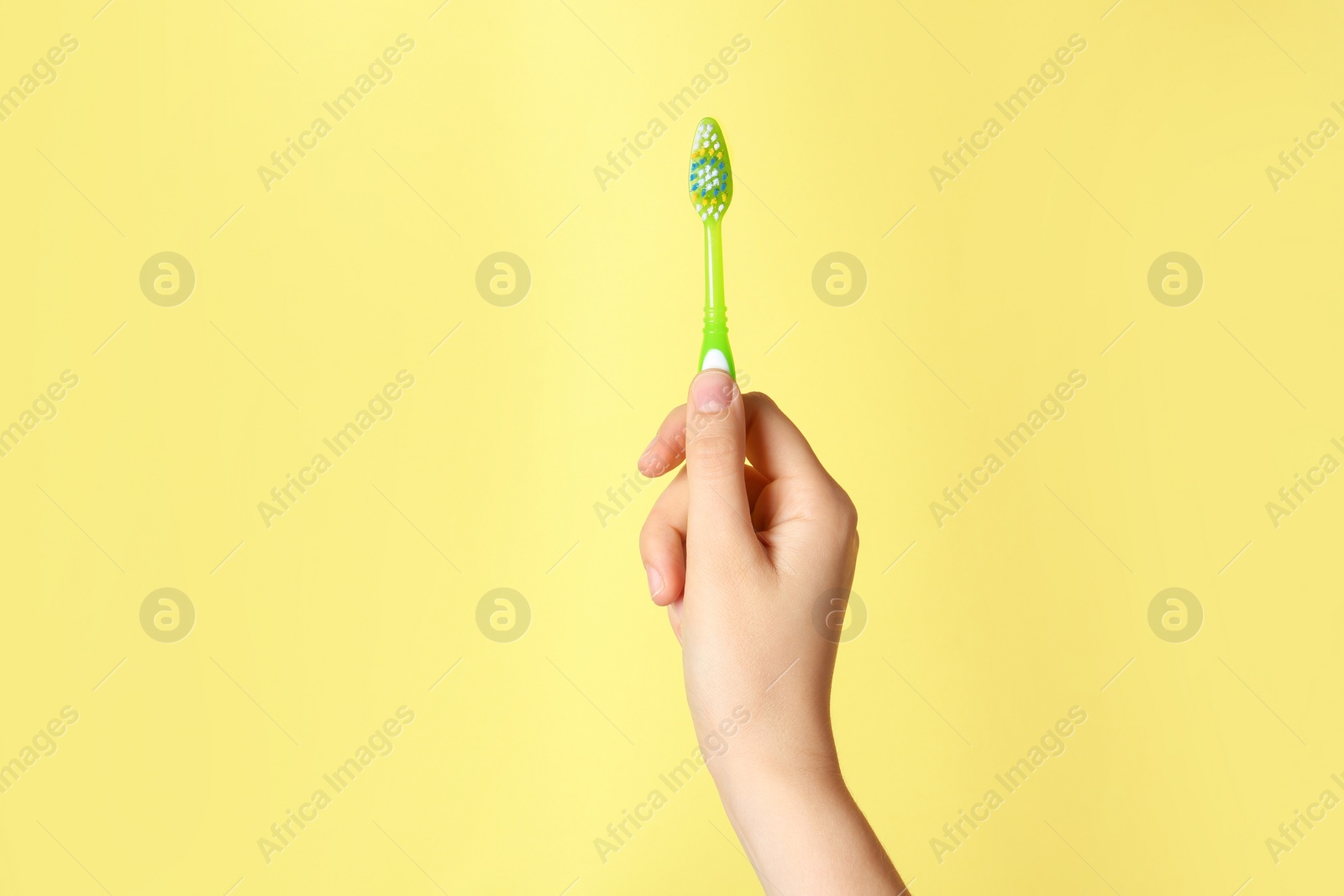 Photo of Woman holding manual toothbrush against color background