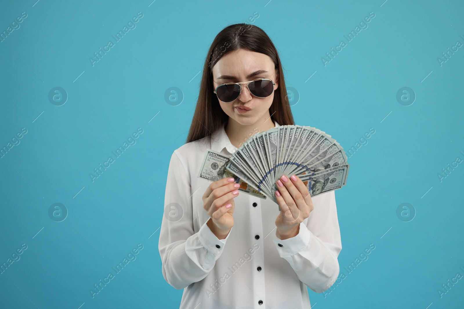 Photo of Woman with dollar banknotes on light blue background