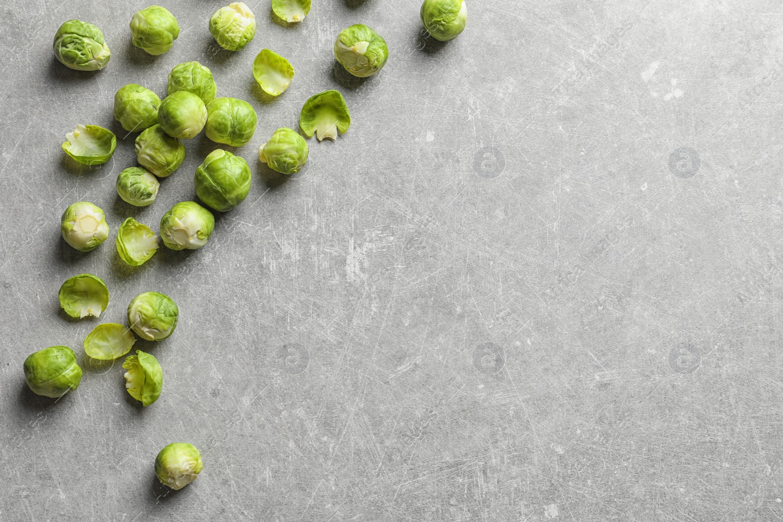 Photo of Fresh Brussels sprouts on grey background, top view with space for text