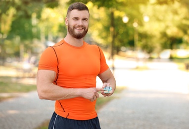 Young man checking pulse after workout in park