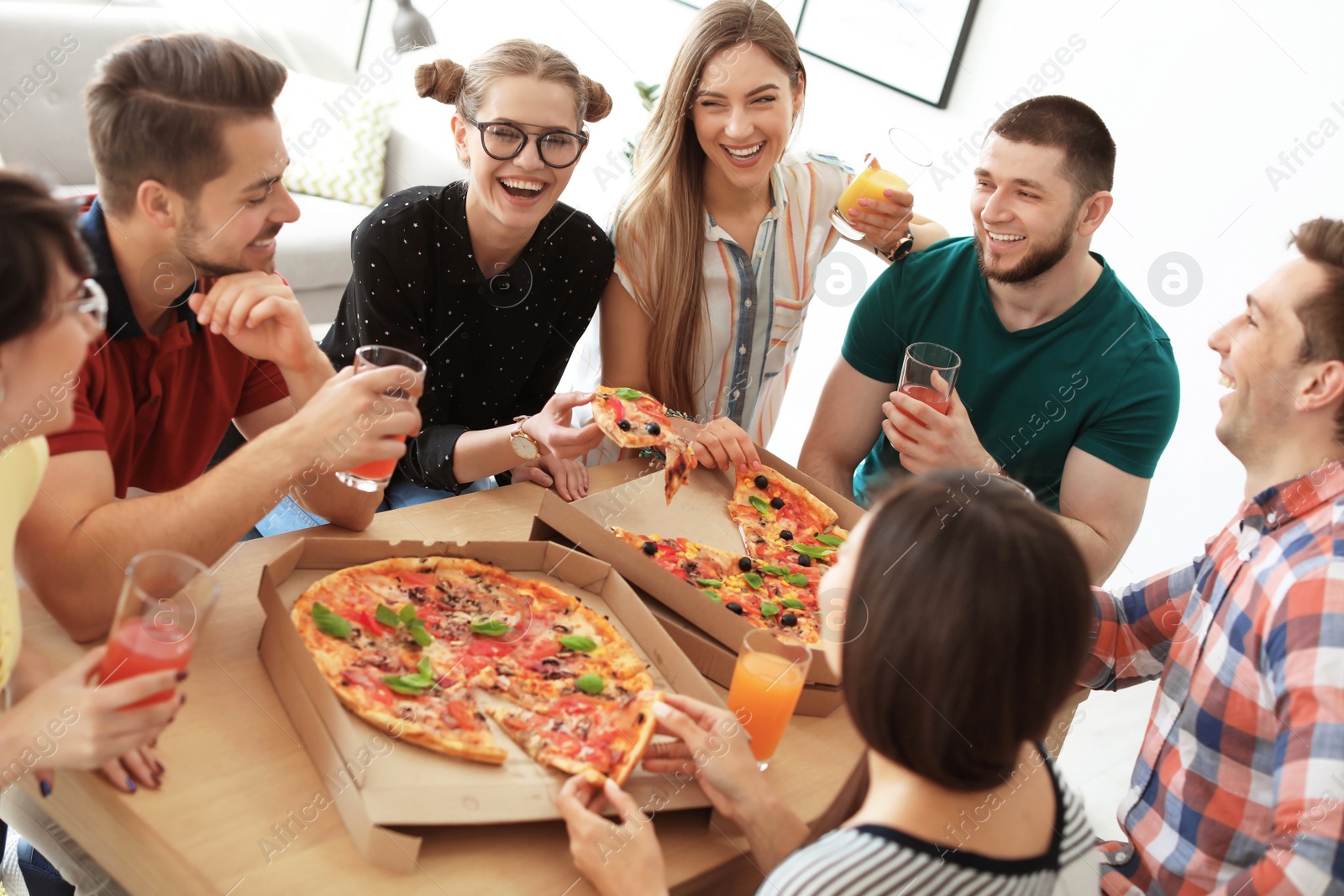 Photo of Young people having fun party with delicious pizza indoors