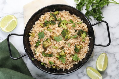 Tasty fried rice with vegetables served on white marble table, flat lay