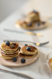 Tasty breakfast. Fresh pancakes with blueberries on white marble table, selective focus