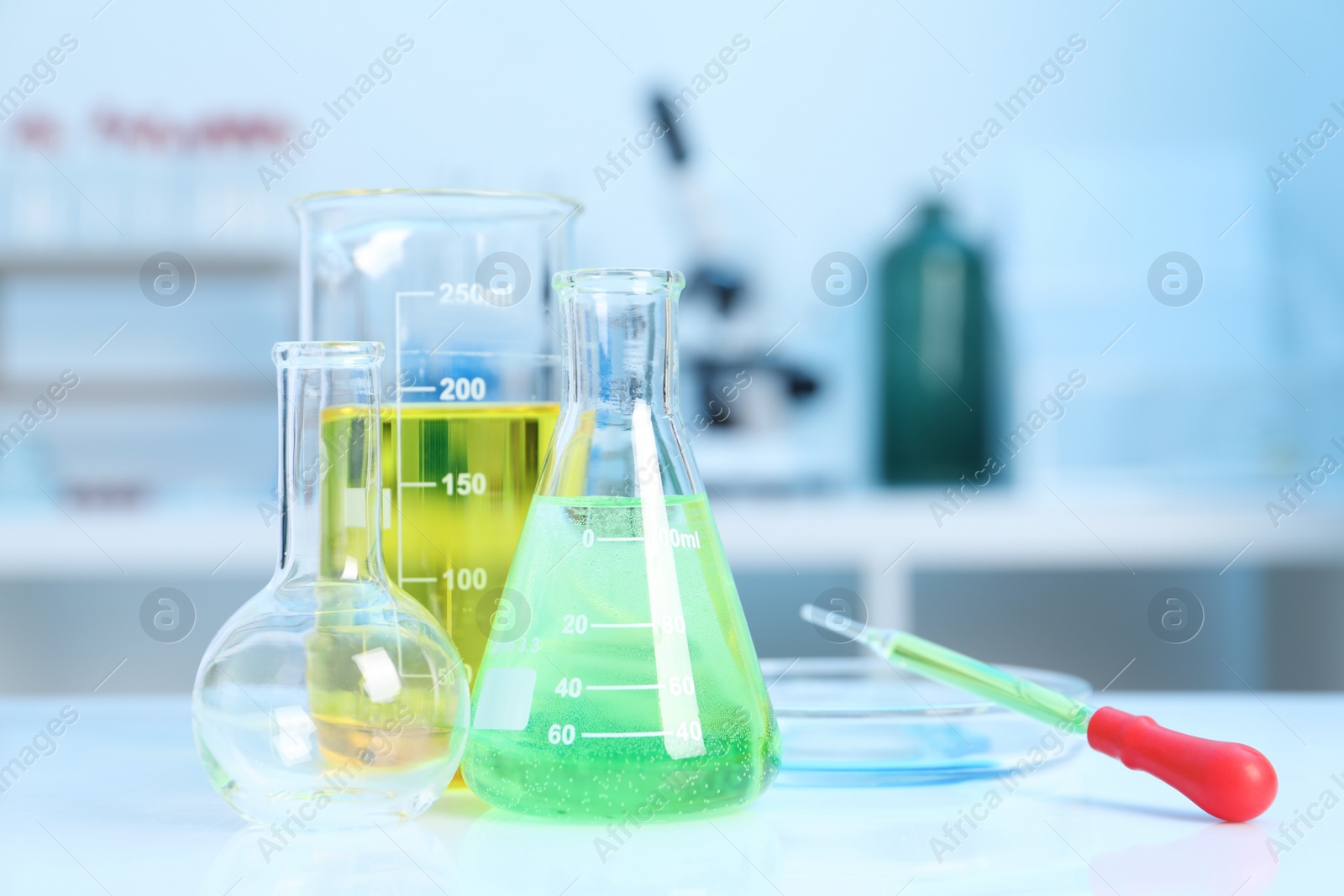 Photo of Laboratory analysis. Different glassware with liquids on white table indoors